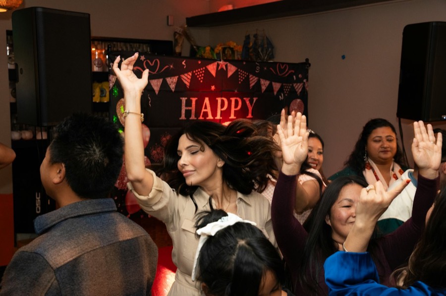 Friends dancing under a Happy birthday banner